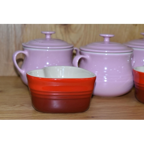 312 - A GROUP OF LE CREUSET, comprising three pale pink stoneware individual casserole dishes with covers,... 