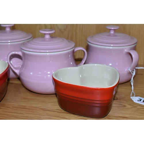 312 - A GROUP OF LE CREUSET, comprising three pale pink stoneware individual casserole dishes with covers,... 