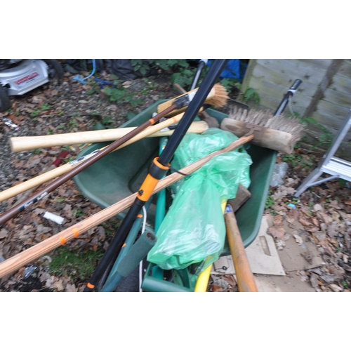 1006 - A PLASTIC BUILDERS WHEELBARROW, containing garden tools