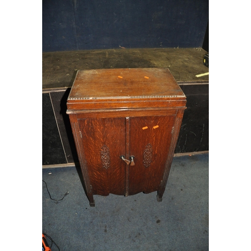 1054 - A VINTAGE VALVE RADIO IN A LIDDED OAK CABINET with a battery inside width 54cm depth 35cm height 91c... 