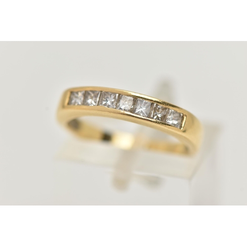 7 - AN 18CT GOLD SEVEN STONE DIAMOND RING, designed as seven princess cut diamonds in a channel setting,... 