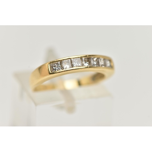 7 - AN 18CT GOLD SEVEN STONE DIAMOND RING, designed as seven princess cut diamonds in a channel setting,... 