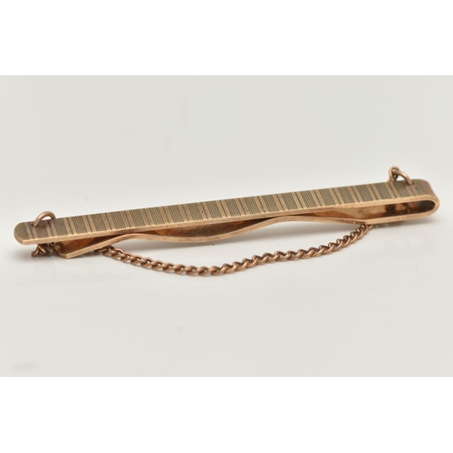 70 - A 9CT GOLD TIE BAR, an engine turned pattern tie bar, fitted with a draping fine curb link chain, ap... 