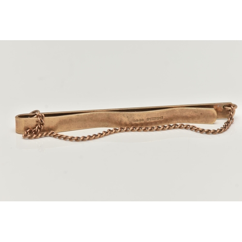 70 - A 9CT GOLD TIE BAR, an engine turned pattern tie bar, fitted with a draping fine curb link chain, ap... 