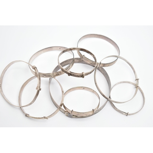 84 - A SELECTION OF MAINLY CHILD'S SILVER AND WHITE METAL BANGLES, to include eight expandable child's ba... 