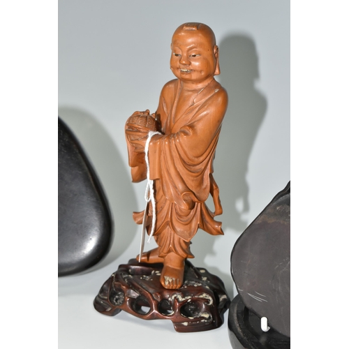 364 - AN ORIENTAL CARVED WOOD FIGURINE, a boxwood carved figure of a smiling Chinese monk bearing a basket... 