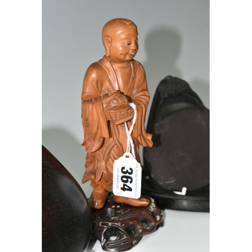 364 - AN ORIENTAL CARVED WOOD FIGURINE, a boxwood carved figure of a smiling Chinese monk bearing a basket... 