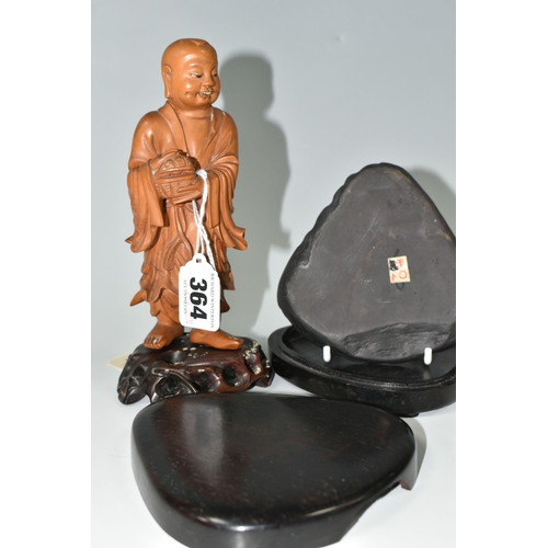 364 - AN ORIENTAL CARVED WOOD FIGURINE, a boxwood carved figure of a smiling Chinese monk bearing a basket... 