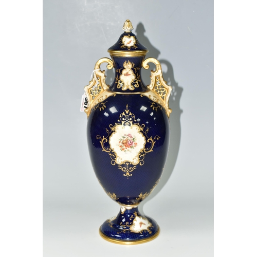 367 - A COALPORT COVERED PEDESTAL VASE, with pierced twin handles, a cobalt blue patterned ground with rai... 