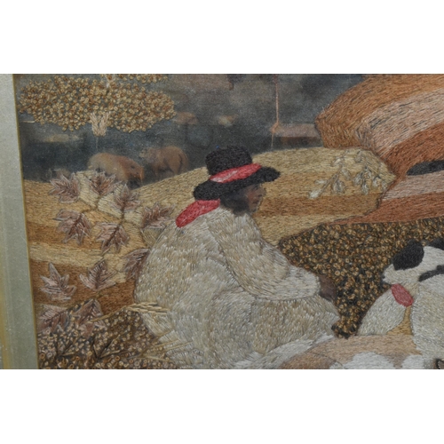 589 - AN EARLY 19TH CENTURY NEEDLEWORK PASTORAL SCENE, depicting two shepherds and their dogs resting in a... 