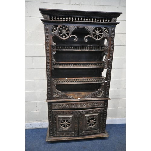 1201 - A TALL HARDWOOD WALL CABINET, with a variety of intricate carved designs, consisting of spindles, wh... 