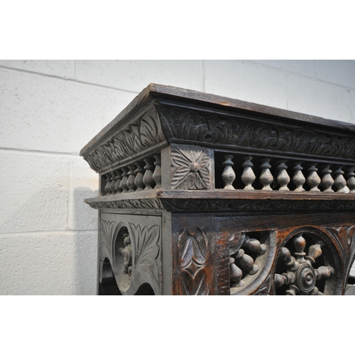 1201 - A TALL HARDWOOD WALL CABINET, with a variety of intricate carved designs, consisting of spindles, wh... 