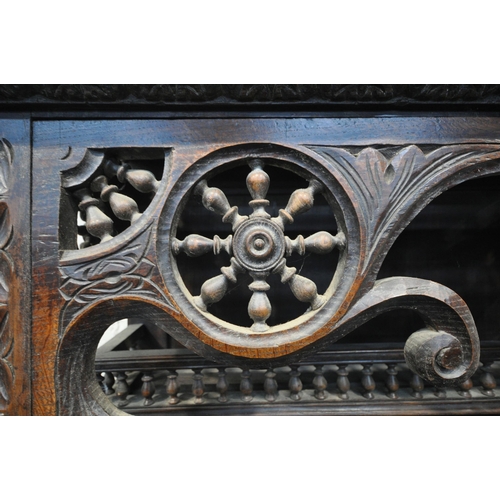 1201 - A TALL HARDWOOD WALL CABINET, with a variety of intricate carved designs, consisting of spindles, wh... 