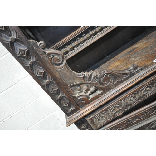 1201 - A TALL HARDWOOD WALL CABINET, with a variety of intricate carved designs, consisting of spindles, wh... 