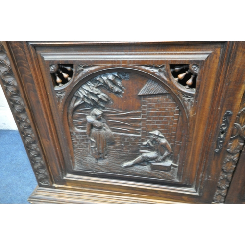 1202 - A CARVED OAK BRETON SIDEBOARD, fitted with an arrangement of five panel doors, depicting humans in v... 