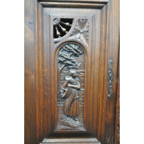 1202 - A CARVED OAK BRETON SIDEBOARD, fitted with an arrangement of five panel doors, depicting humans in v... 