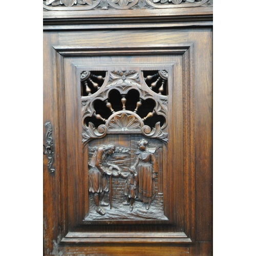 1202 - A CARVED OAK BRETON SIDEBOARD, fitted with an arrangement of five panel doors, depicting humans in v... 