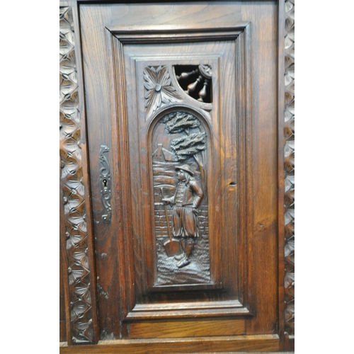 1202 - A CARVED OAK BRETON SIDEBOARD, fitted with an arrangement of five panel doors, depicting humans in v... 