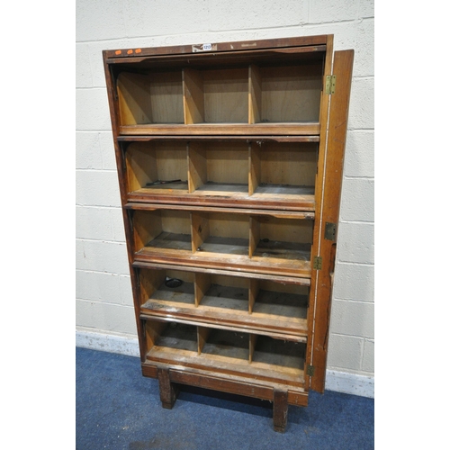 1213 - A GOVERNMENT ISSUE STAVERTON OAK BOOKCASE, with five rise and fall doors, enclosing an arrangement o... 