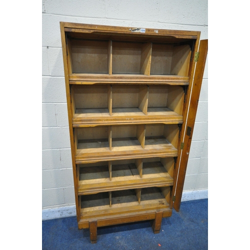 1216 - A GOVERNMENT ISSUE STAVERTON OAK BOOKCASE, with five rise and fall doors, enclosing an arrangement o... 