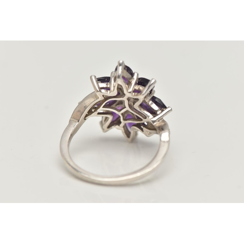 10 - AN AMETHYST FLOWER RING, designed as amethyst petals to the cross over design shoulders, stamped 925... 