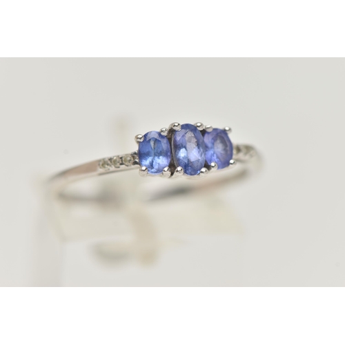 25 - A 14CT WHITE GOLD TANZANITE AND DIAMOND RING, three oval cut tanzanite, each four claw set, small si... 