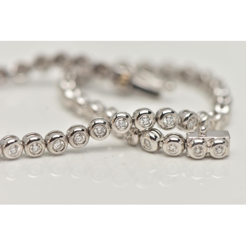 9 - A WHITE METAL DIAMOND LINE BRACELET, designed as fifty-six brilliant cut diamonds each in a rub over... 