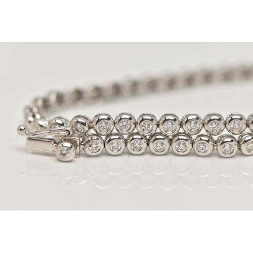 9 - A WHITE METAL DIAMOND LINE BRACELET, designed as fifty-six brilliant cut diamonds each in a rub over... 