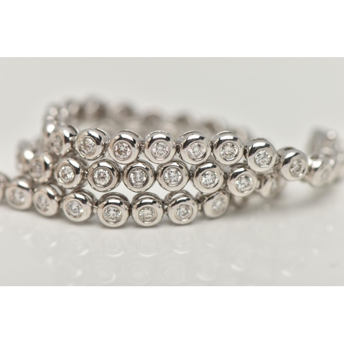 9 - A WHITE METAL DIAMOND LINE BRACELET, designed as fifty-six brilliant cut diamonds each in a rub over... 