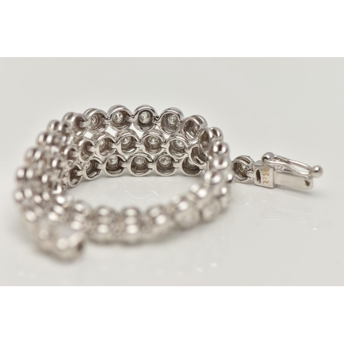 9 - A WHITE METAL DIAMOND LINE BRACELET, designed as fifty-six brilliant cut diamonds each in a rub over... 