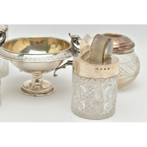 106 - FIVE SILVER TOPPED JARS AND A TWIN HANDLE DISH, to include two glass toilet jars with open silver to... 