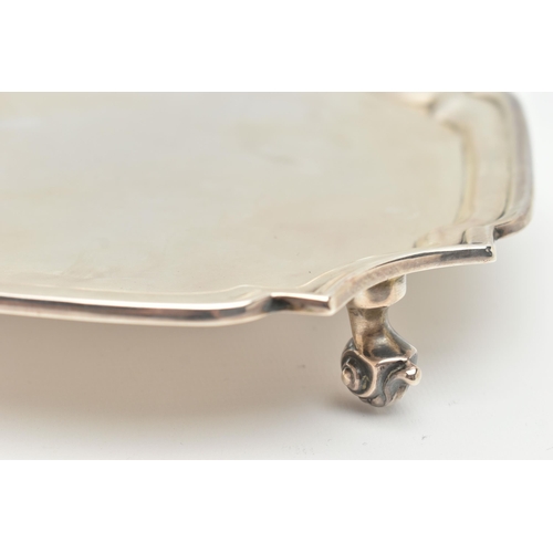 93 - A GEORGE V SILVER WAITER OF SHAPED SQUARE FORM, pie crust border, plain centre, on four short scroll... 