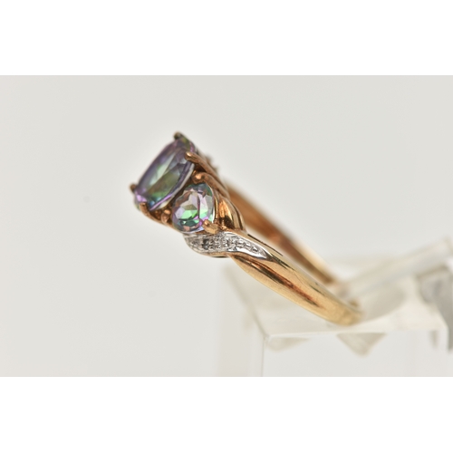 17 - A 9CT GOLD MYSTIC TOPAZ THREE STONE RING, set with a central oval cut mystic topaz flanked with hear... 