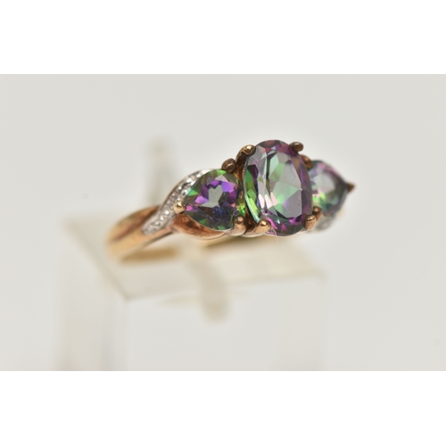 17 - A 9CT GOLD MYSTIC TOPAZ THREE STONE RING, set with a central oval cut mystic topaz flanked with hear... 