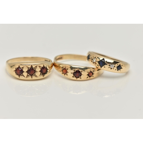 16 - THREE 9CT GOLD GEM SET RINGS, the first a gents three stone garnet ring with star setting detail, ha... 