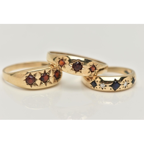 16 - THREE 9CT GOLD GEM SET RINGS, the first a gents three stone garnet ring with star setting detail, ha... 