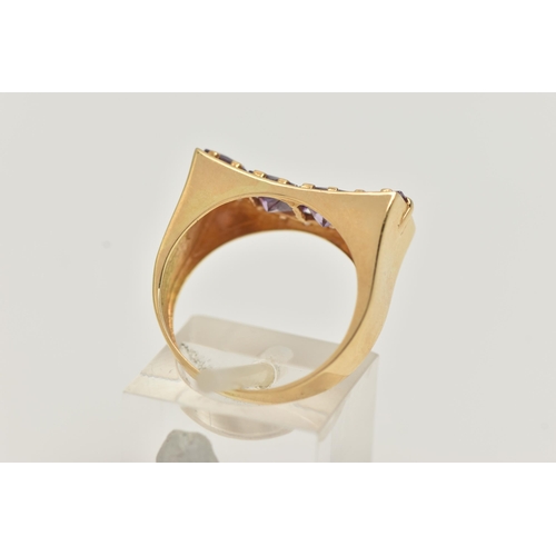 18 - A YELLOW METAL DRESS RING, a rectangular form mount with concave detail, set with four purple square... 