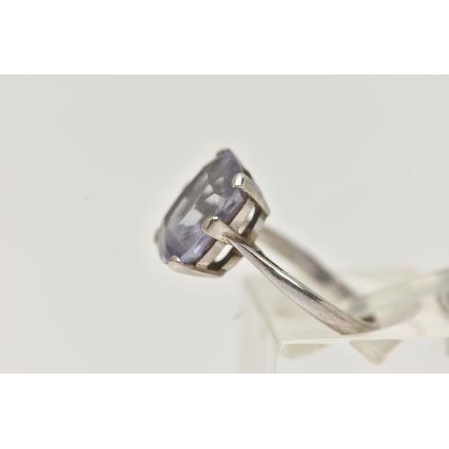 22 - A GEM SET RING, an elongated cushion cut bule stone, assessed as synthetic sapphire, prong set in wh... 