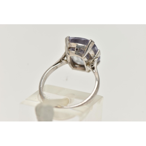 22 - A GEM SET RING, an elongated cushion cut bule stone, assessed as synthetic sapphire, prong set in wh... 