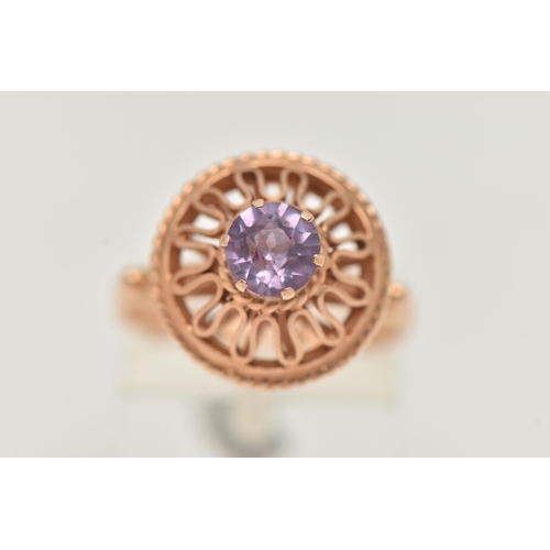 26 - A DECORATIVE SYNTHETIC COLOUR CHANGE SAPPHIRE RING, designed as a circular purple synthetic colour c... 