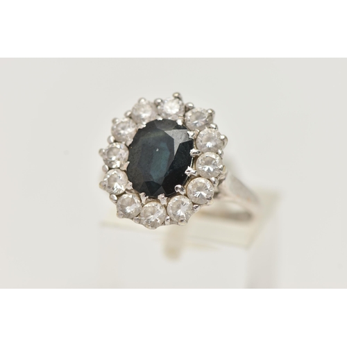 34 - A 9CT WHITE GOLD SAPPHIRE AND PASTE CLUSTER RING, designed as a central oval sapphire within a circu... 