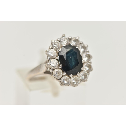 34 - A 9CT WHITE GOLD SAPPHIRE AND PASTE CLUSTER RING, designed as a central oval sapphire within a circu... 