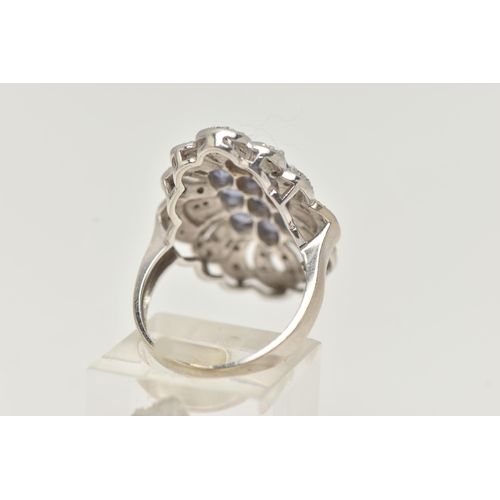 62 - A 14CT WHITE GOLD TANZANITE AND DIAMOND DRESS RING, designed as a central cluster of oval cut tanzan... 