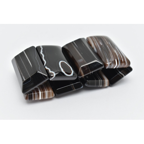 71 - A BANDED AGATE BRACELET, eight panels of carved banded agate, on a stretch bracelet, approximate gro... 