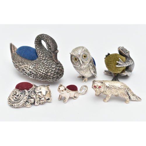 132 - FIVE PIN CUSHIONS AND A FIGURINE, to include a silver swan pin cushion, hallmarked 'Ari D Norman' Lo... 