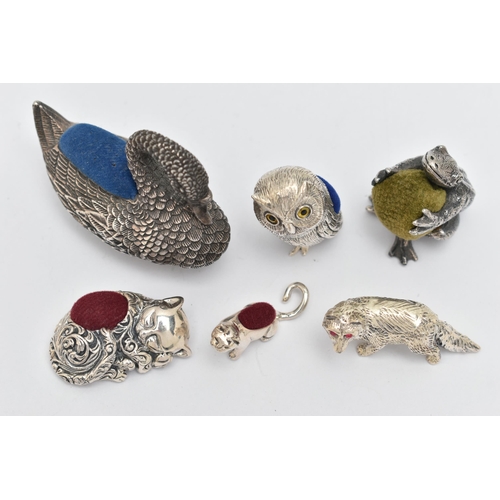 132 - FIVE PIN CUSHIONS AND A FIGURINE, to include a silver swan pin cushion, hallmarked 'Ari D Norman' Lo... 