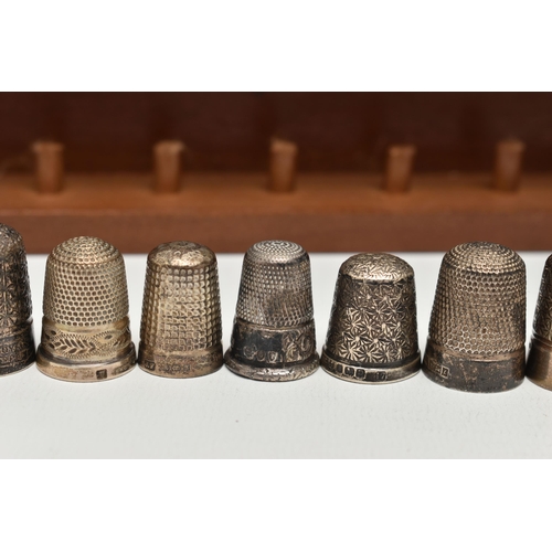 147 - A SELECTION OF SILVER THIMBLES AND TWO DISPLAY SHELVES, to include twenty-one thimbles, various desi... 