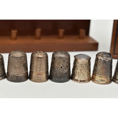 147 - A SELECTION OF SILVER THIMBLES AND TWO DISPLAY SHELVES, to include twenty-one thimbles, various desi... 