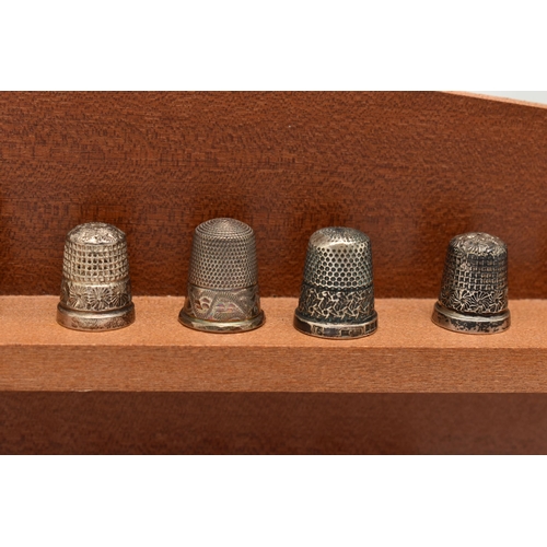 148 - A SELECTION OF SILVER THIMBLES AND TWO DISPLAY SHELVES, to include twenty-two thimbles, various desi... 