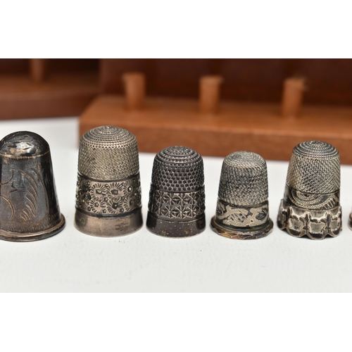 148 - A SELECTION OF SILVER THIMBLES AND TWO DISPLAY SHELVES, to include twenty-two thimbles, various desi... 